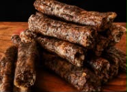 Sticks of dried droëwors stacked on a board