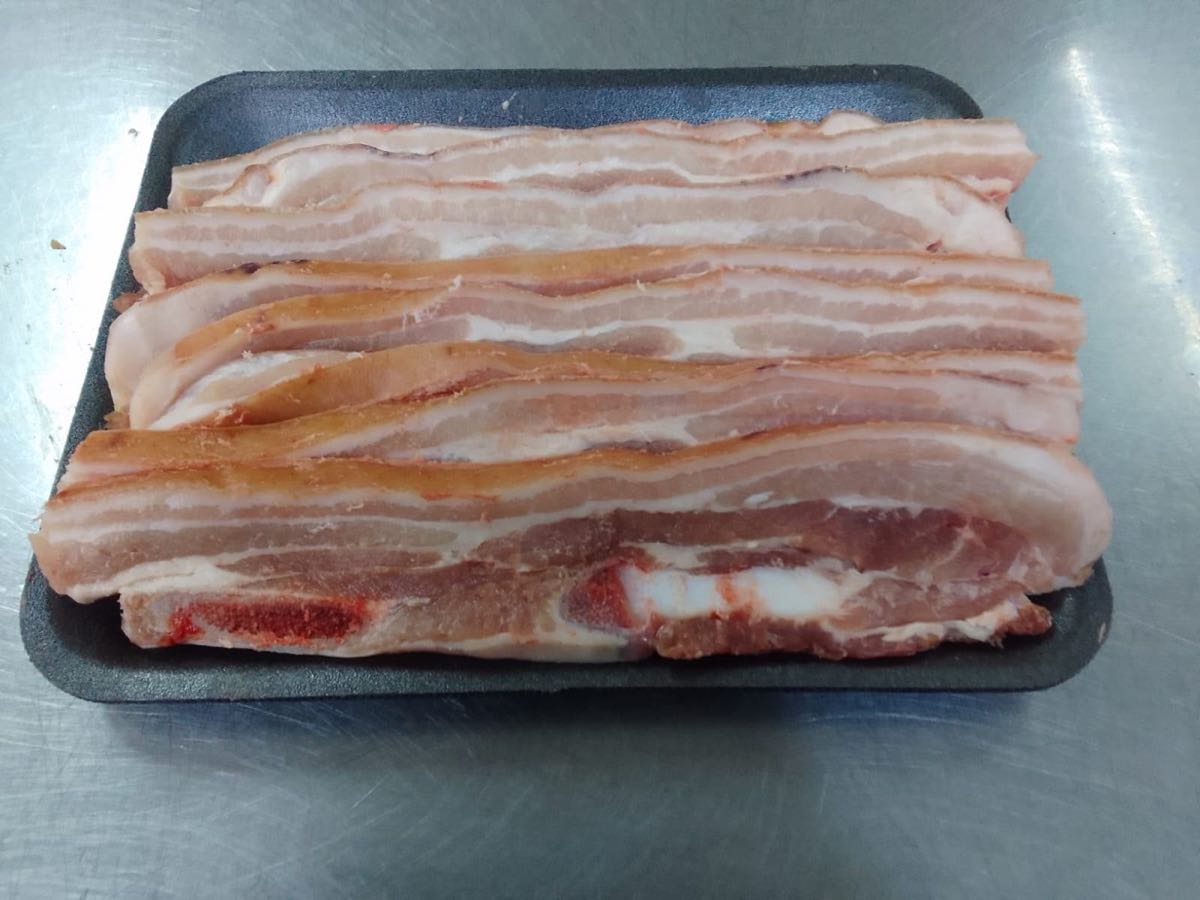 Sliced streaky pork belly rashers on a tray